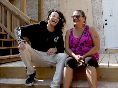 Mary of Zoongizi Ode and Michael sitting on a porch